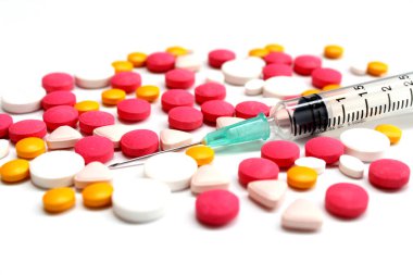 Several kinds of drug tablet and 3 ml syringe isolated on the white background