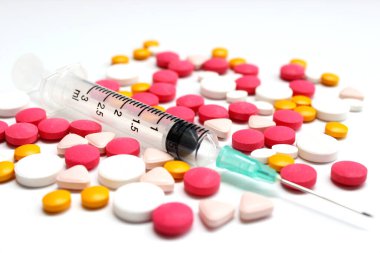 Several kinds of drug tablet and 3 ml syringe isolated on the white background