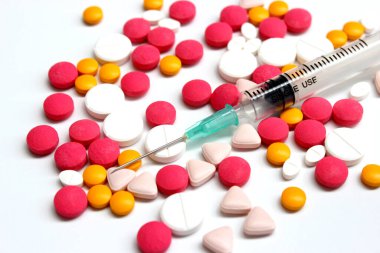 Several kinds of drug tablet and 3 ml syringe isolated on the white background