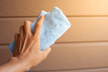 Bir bez parçasıyla beyaz bir havluyu tutan el.