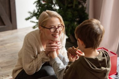 Anne ve oğlu evde kurabiye yiyorlar.