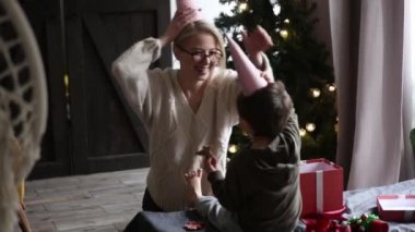Anne ve oğlu evde komik Noel şapkaları takıyor.