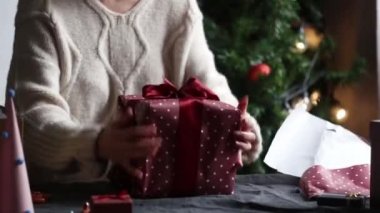 Evde hediye paketleyen bir kadın. 