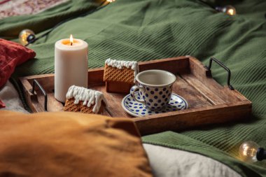 Yatakta bir fincan kahve ve Noel kurabiyesi