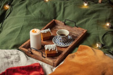 Yatakta bir fincan kahve ve Noel kurabiyesi