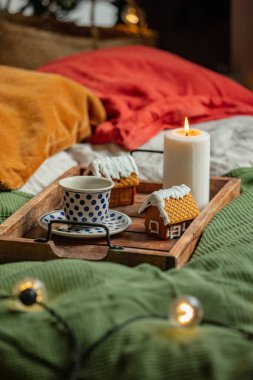Yatakta bir fincan kahve ve Noel kurabiyesi