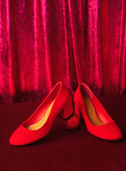 Noel Bebekli Kırmızı Kadın Ayakkabıları Arka Planda Kırmızı Perdeler — Stok fotoğraf