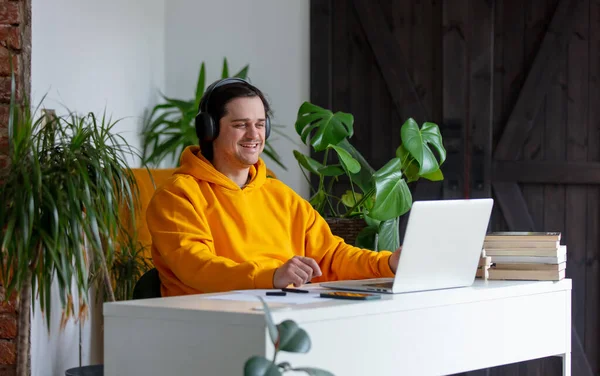 Νεαρός Άνδρας Ακουστικά Που Εργάζεται Στο Γραφείο Στο Σπίτι — Φωτογραφία Αρχείου