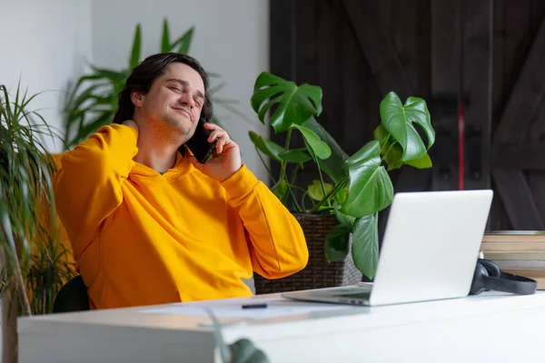 Ung Man Talar Med Mobiltelefon När Han Arbetar Hemmakontoret — Stockfoto