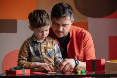 Baba ve oğul anneler günü için bir hediye hazırlayın.