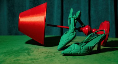Masada yeşil topuklar ve kırmızı lamba ve arka planda yeşil perdeler.