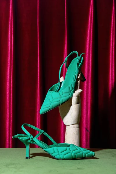 Ahşap Kırmızı Perde Arkasında Yeşil Topuklu Ayakkabı Tutuyor — Stok fotoğraf