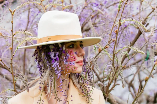 藤の花の周りに花びらが咲く美しい女性木の枝 — ストック写真