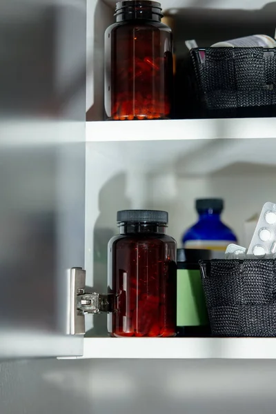 Bottles with pills and medicals in cabinet