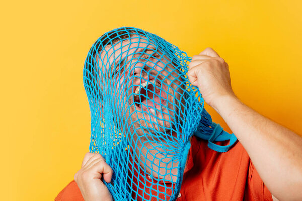 Guy with blue net on head on yellow background