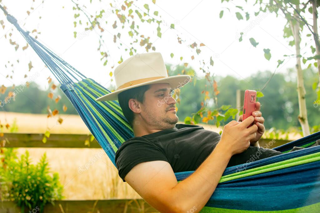 Man using mobile phone in hammock
