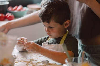 mother and son preparing flour for cookies in the kitchen