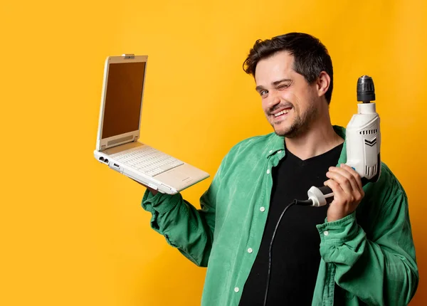 Stilvoller Mann Grünen Hemd Mit Bohrmaschine Und Laptop Auf Gelbem — Stockfoto