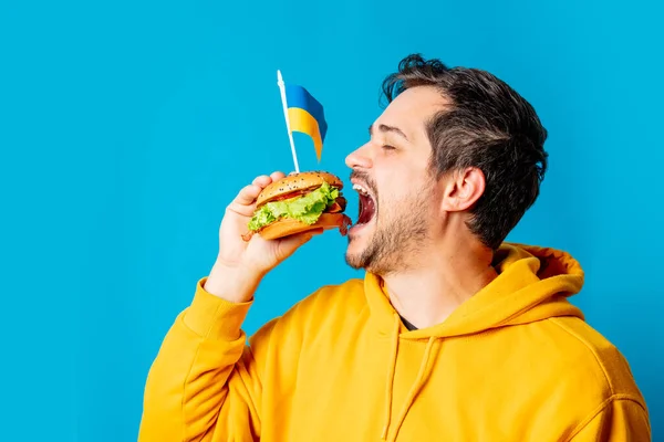 Witte Man Gele Hoodie Met Hamburger Oekraïense Vlag Blauwe Achtergrond — Stockfoto