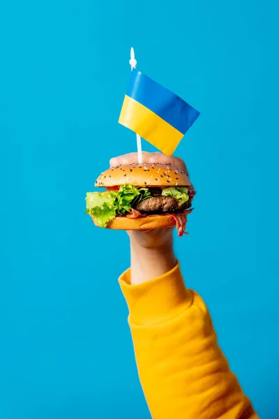 Mężczyzna Trzymać Burger Ukraińska Flaga Niebieskim Tle — Zdjęcie stockowe