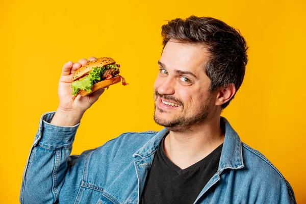 Hongerige Man Met Hamburger Gele Achtergrond — Stockfoto