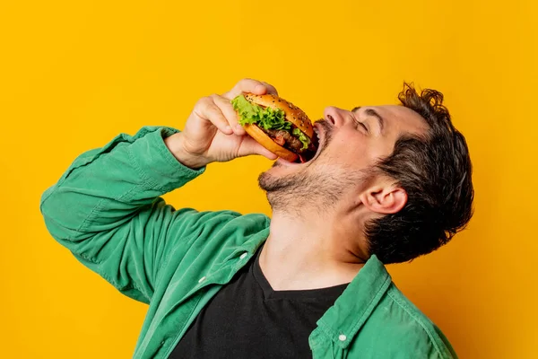 Uomo Affamato Con Hamburger Sfondo Giallo — Foto Stock