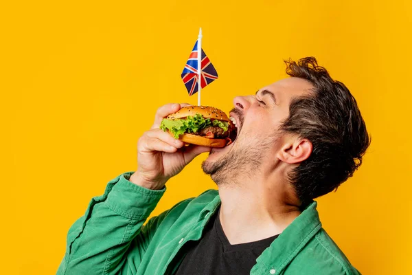 Glimlachende Man Met Britse Vlag Hamburger Gele Achtergrond — Stockfoto