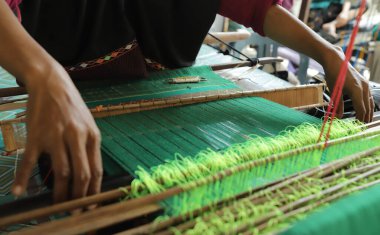 close up of hands doing weaving work using traditional tools clipart