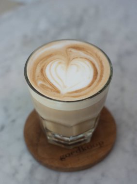 Seramik masada bir bardak fındıklı latte.