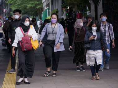 Jakarta, Endonezya-07 Mart 2022: Dukuh Atas tüneline girip çıkan bir grup insan.