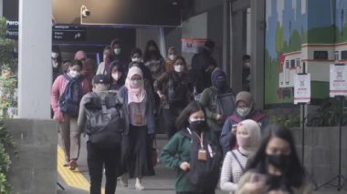 Jakarta, Endonezya-06 Mart 2022: Ağır çekim Tren yolcuları koruyucu maskeler takarak Jakarta 'nın Dukuh Atas tren istasyonundan çıkıyorlar.