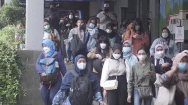 Jakarta, Endonezya-06 Mart 2022: Ağır çekim Tren yolcuları koruyucu maskeler takarak Jakarta 'nın Dukuh Atas tren istasyonundan çıkıyorlar.