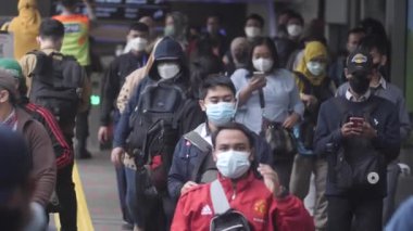 Jakarta, Endonezya-06 Mart 2022: Ağır çekim Tren yolcuları koruyucu maskeler takarak Jakarta 'nın Dukuh Atas tren istasyonundan çıkıyorlar.