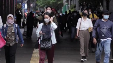 Jakarta, Endonezya-06 Mart 2022: Ağır çekim Tren yolcuları koruyucu maskeler takarak Jakarta 'nın Dukuh Atas tren istasyonundan çıkıyorlar.