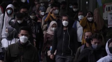 Jakarta, Endonezya-06 Mart 2022: Ağır çekim Tren yolcuları koruyucu maskeler takarak Jakarta 'nın Dukuh Atas tren istasyonundan çıkıyorlar.