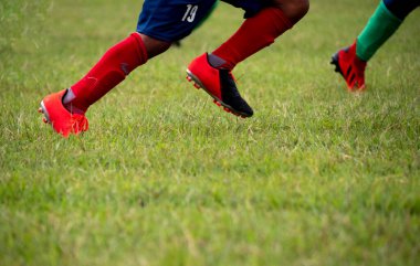  Futbol ayakkabısı giyen futbolcu seçici odaklı çimenlerde koşuyor..