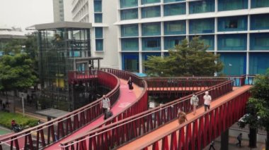 Jakarta, Endonezya - 01 Temmuz 2022: Güney Jakarta, Setiabudi 'deki Pinisi yaya köprüsünden ağır çekimde geçen insanlar.