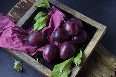 Tahta bir kutuda yapraklı erikler