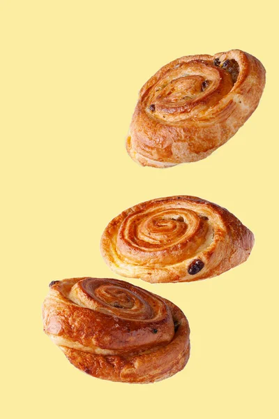 buns with raisins flying food selective focus on yellow background