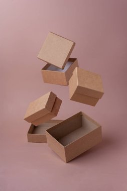 Çevre dostu el sanatları kutuları pembe arka planda seçici odaklı boks gününde havada uçar