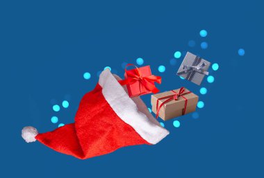 Noel Baba şapkası ve hediyeler mavi arka planda