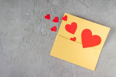 Kırmızı kağıt kalpler sarı bir zarftan uçar, boşluğu kopyala