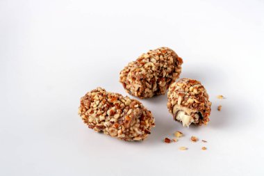 Beyaz arkaplanda çikolata, fındık ve krema içeren Asya şekerleri, seçici odak