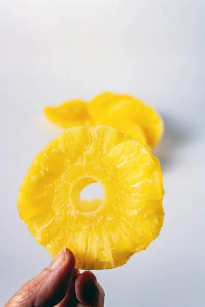Ein Stück Getrocknete Ananas Der Hand Einer Frau Auf Weißem — Stockfoto