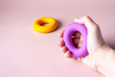 Erkek eli lastik bir bilek çalıştırıcısını sıkıyor, kopyalama alanı