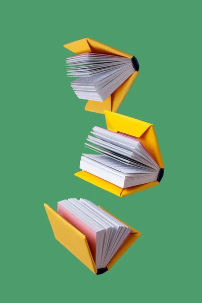 Libros Miniatura Una Cubierta Amarilla Vuelan Sobre Fondo Verde — Foto de Stock