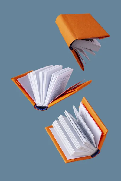 Libros Miniatura Una Cubierta Naranja Vuelan Sobre Fondo Azul —  Fotos de Stock