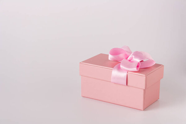 pink gift box with satin ribbon isolated on white background, copy space