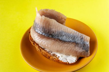 Yağlı ringa balıklı sandviç, yakın plan.