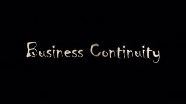İşletme Sürekliliği kelimesinin yanık metni. Business Continuity 'nin altın parıltısı kelime döngüsü animasyonu QuickTime Alpha Channel ProRes 4444 kullanılarak izole edilmiş reklam kavramını teşvik ediyor..